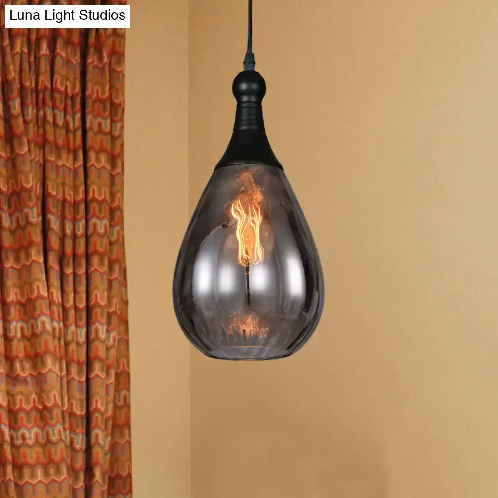 A sleek black daisy industrial black brass teardrop ceiling light with smoked glass shade and exposed filament bulb