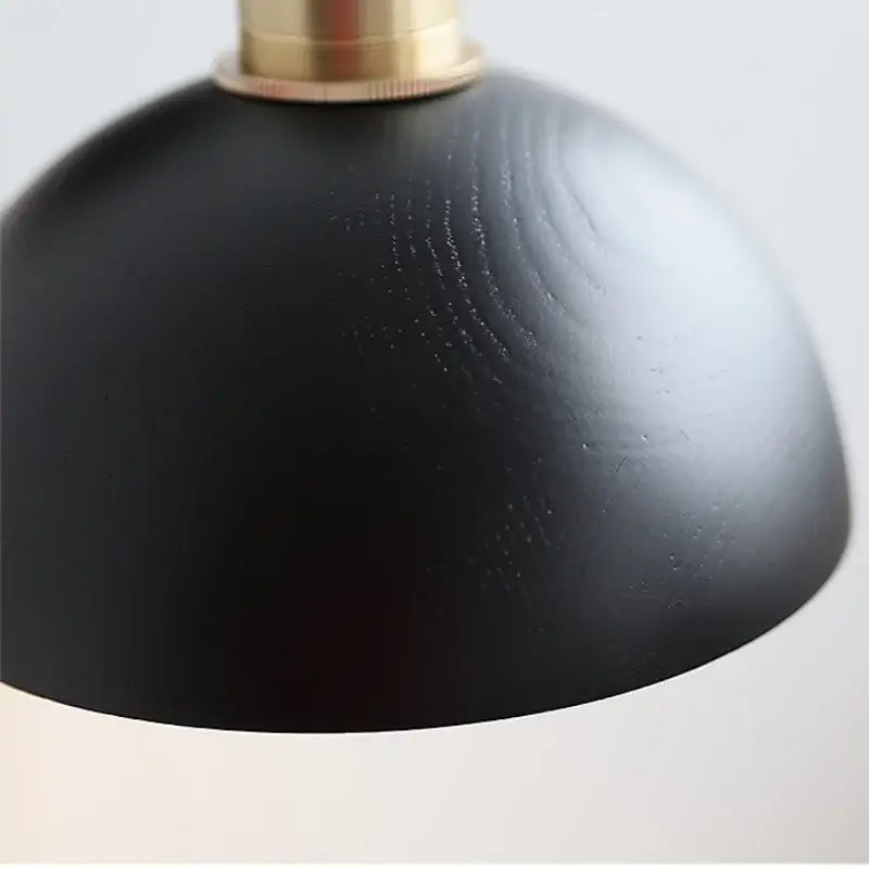 Industrial black and brass wall light fixture featuring a black matte wooden dome lampshade bedroom sconce