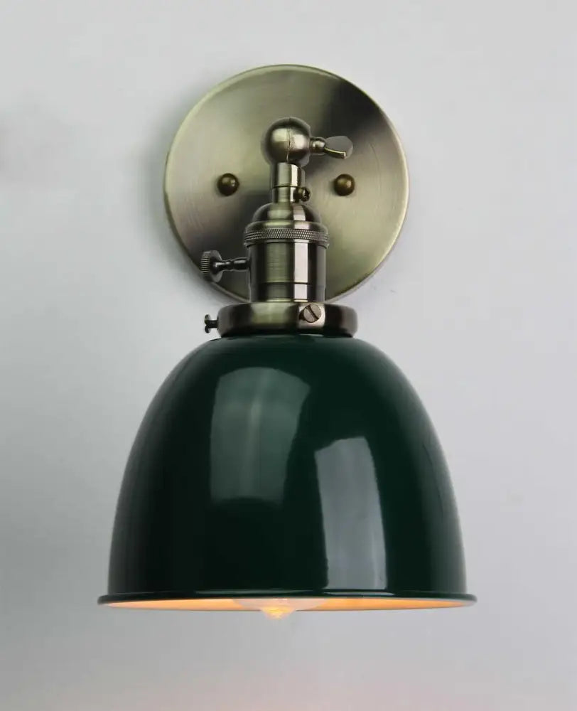 Dark green enamel dome wall sconce with brushed brass mounting plate featuring industrial black wall sconce design