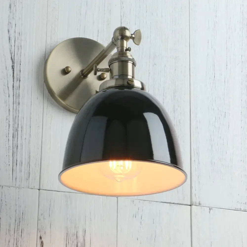 Black wall sconce industrial design with a black enamel dome and brushed brass adjustable arm for bedroom use