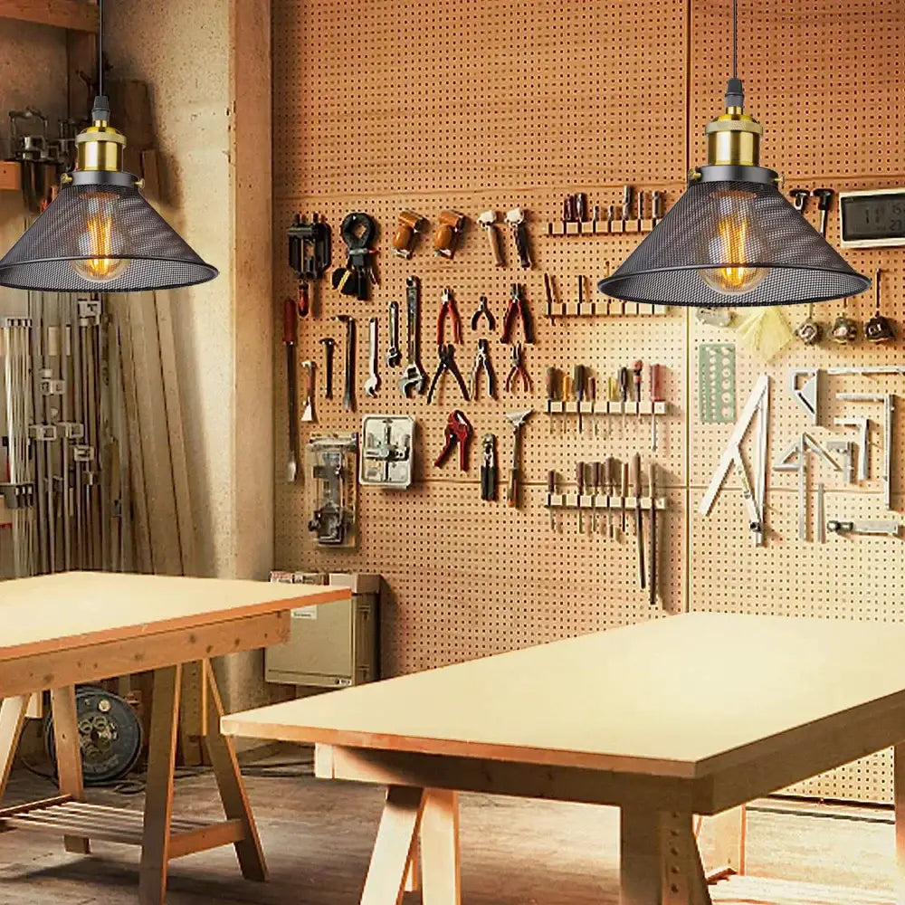 Industrial black cage pendant light with brass hardware and black mesh shade featuring glowing filament bulb decorbites black cage