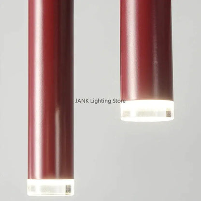 Two sleek deep red metallic pendant lights with clear acrylic bases complement decorbites circular ring pendant