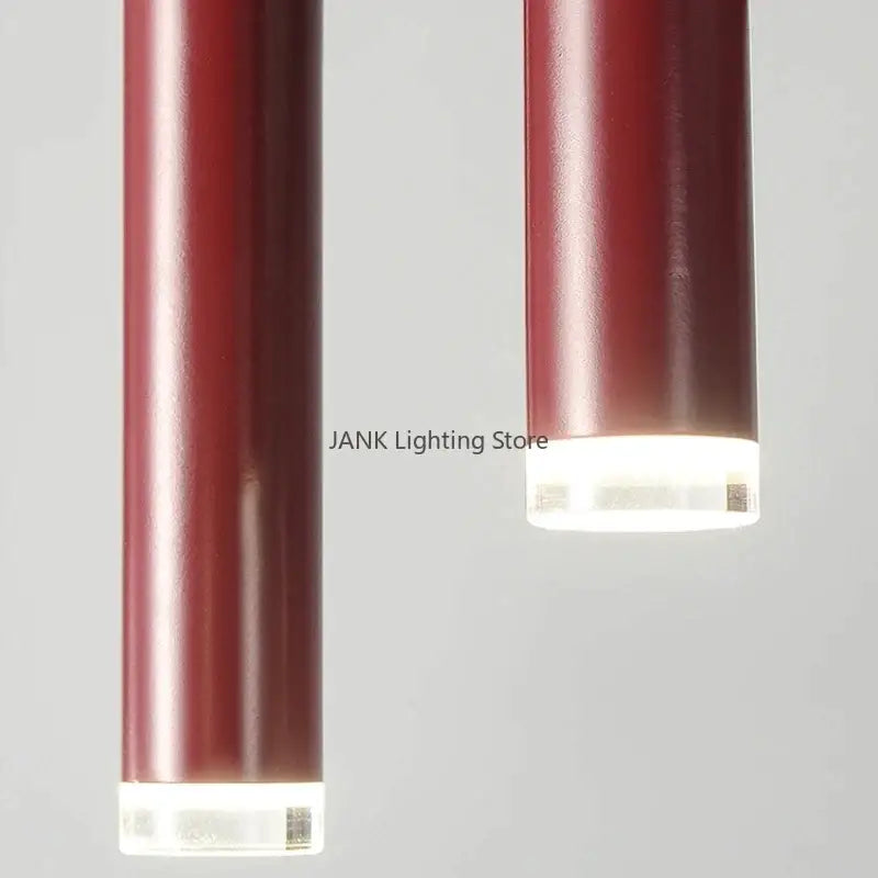 Two sleek deep red metallic pendant lights with clear acrylic bases complement decorbites circular ring pendant