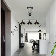 Black industrial farmhouse barn island pendant with three cage-shade lamps and adjustable chain cord length pulley mechanism