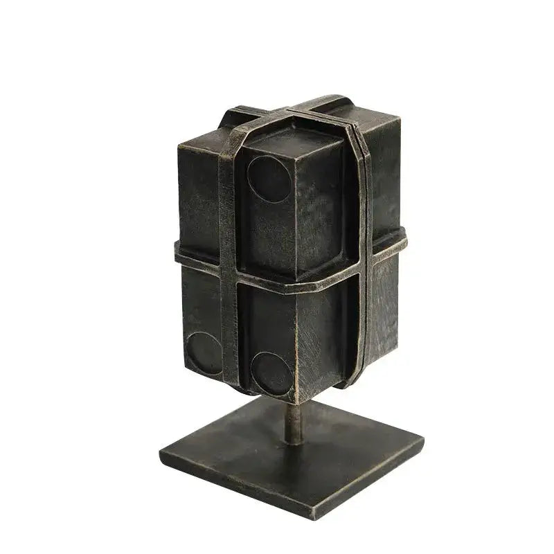 Industrial black geometric block binding metal bookends featuring a dark metallic box-like sculpture with circular cutouts