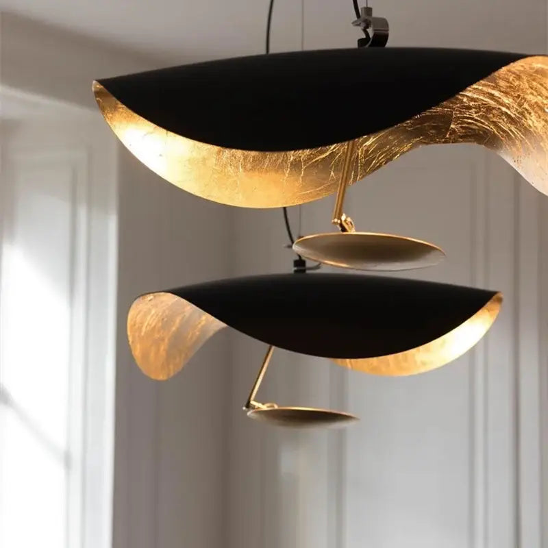 Industrial black and gold lotus leaf pendant light with flowing sculptural design for dining room decorbites lederam manta