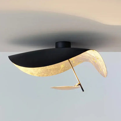 Modern black and gold leaf-shaped industrial pendant light with sleek curved design for dining room decorbites lederam manta