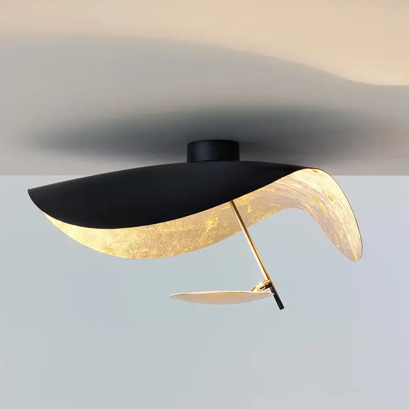 Modern black and gold leaf-shaped industrial pendant light with sleek curved design for dining room decorbites lederam manta