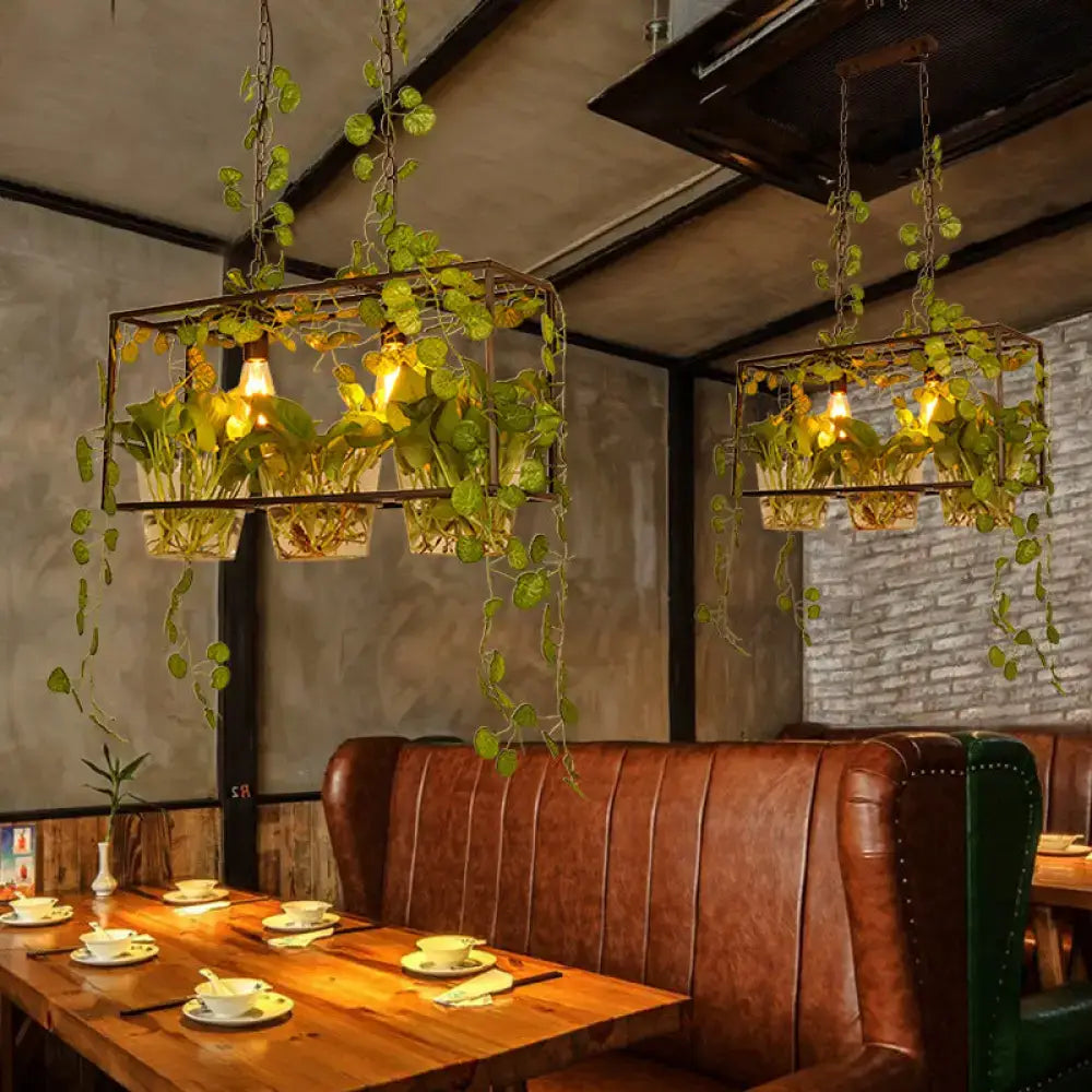 Industrial black and green plant pendant light with chain cord length featuring metal frame and cascading green vines