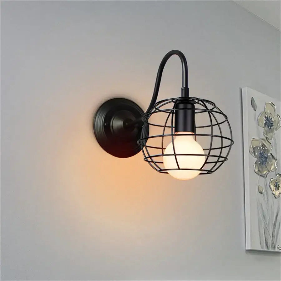 Black wrought iron cage wall sconce with spherical wire cage and illuminated bulb for industrial decorbites iron cage lighting