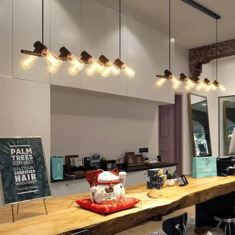 Industrial black kitchen island chandelier with edison bulbs beside a white ceramic lucky cat decor on red cushion decorbites industrial kitchen