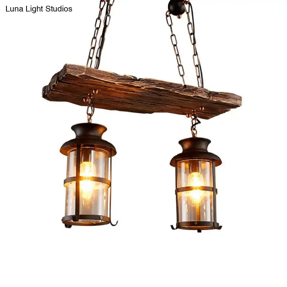 DecorBites industrial pendant light with two dark metal lantern fixtures featuring clear glass and rustic wood beam
