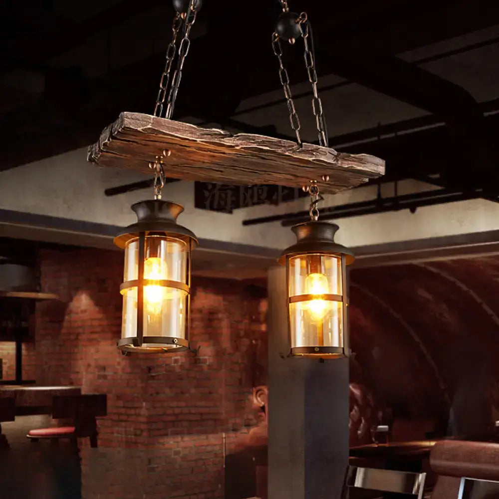 Rustic wooden beam suspending two black decorbites industrial pendant lights with clear glass and brass accents hanging lamps