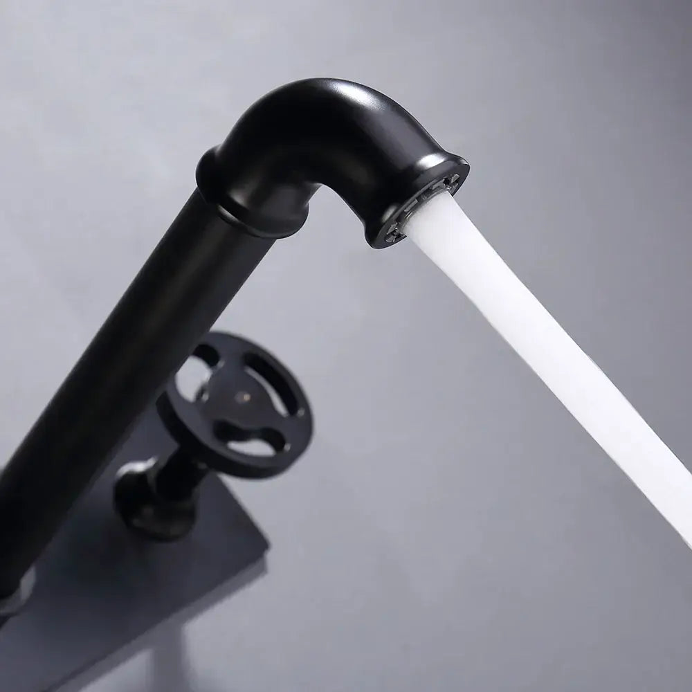 Industrial black matte wall mounted basin faucet with curved spout and round handwheel handle by decorbites black wall mounted