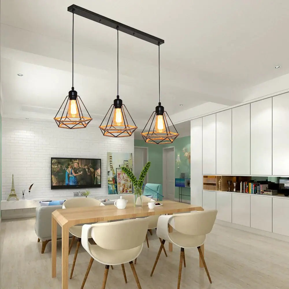 Black metal geometric pendant lights with warm filament bulbs hang above wooden table in decorbites industrial hanging lamp