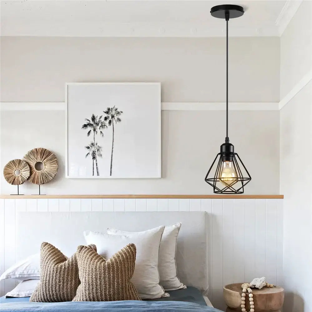 Industrial black metal mini pendant light with geometric cage design and exposed bulb for dining room use