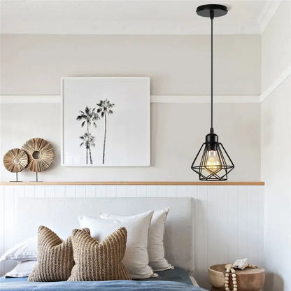 Industrial black metal mini pendant light with geometric cage design and exposed bulb for dining room use