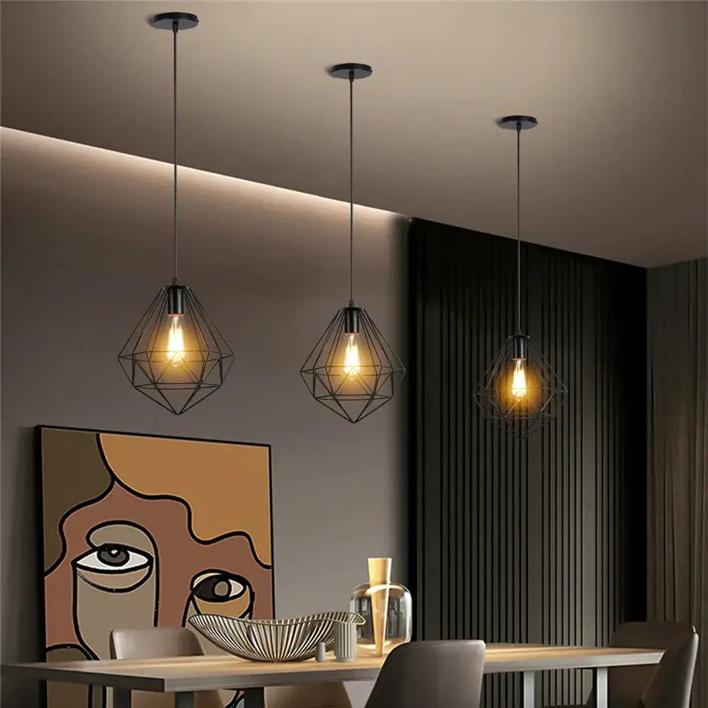 Three black industrial metal cage mini pendant lights with exposed filament bulbs for dining room pendant light