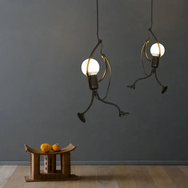 Industrial black metal cage pendant light with running figure design glowing white bulbs and gold accents for kitchen decorbites industrial led decor