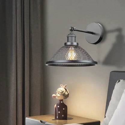 Industrial black metal cage wall lamp with mesh shade and exposed bulb for bedroom decorbites black metal sconce