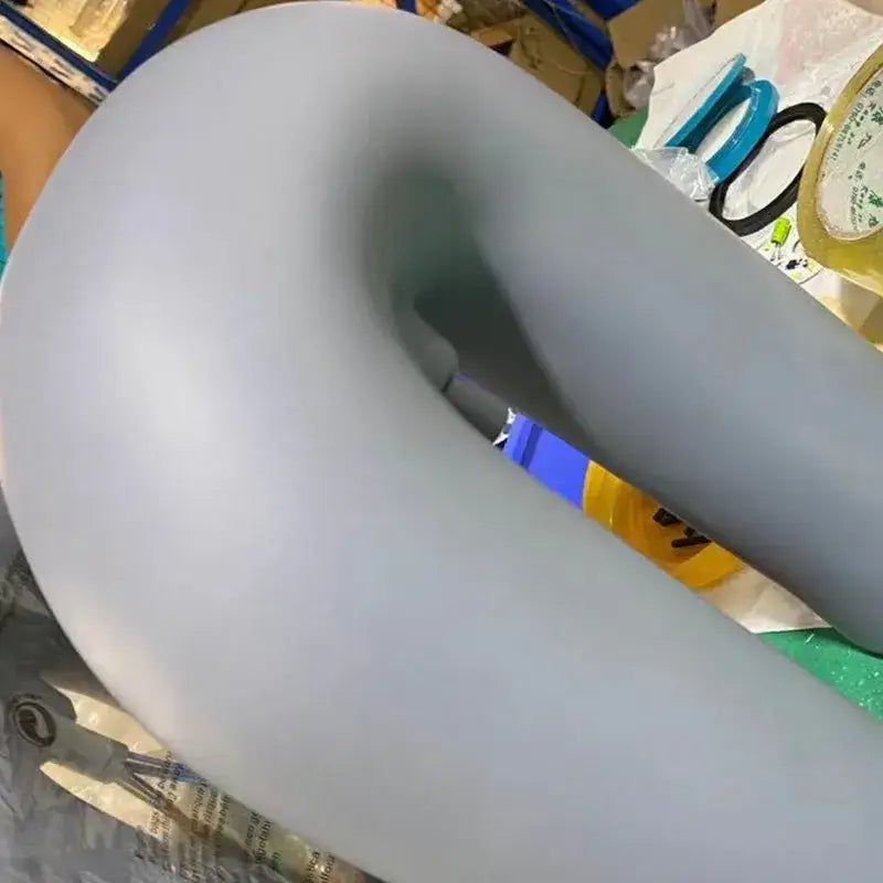 A smooth matte light gray silicone donut-shaped element of the decorbites cirkus led industrial black minimalist chandelier