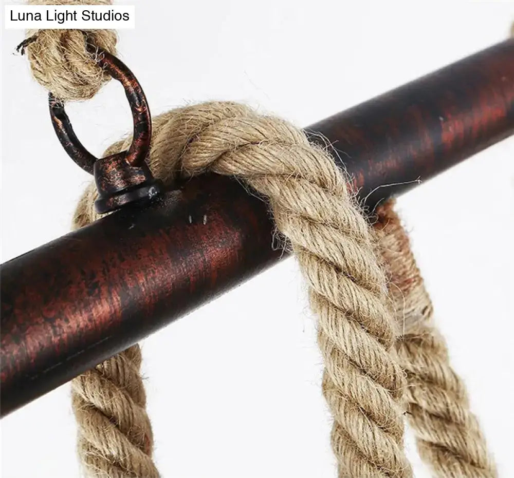 Thick beige braided rope with dark rustic metal ring for industrial black pipe and rope chandelier on linear restaurant island