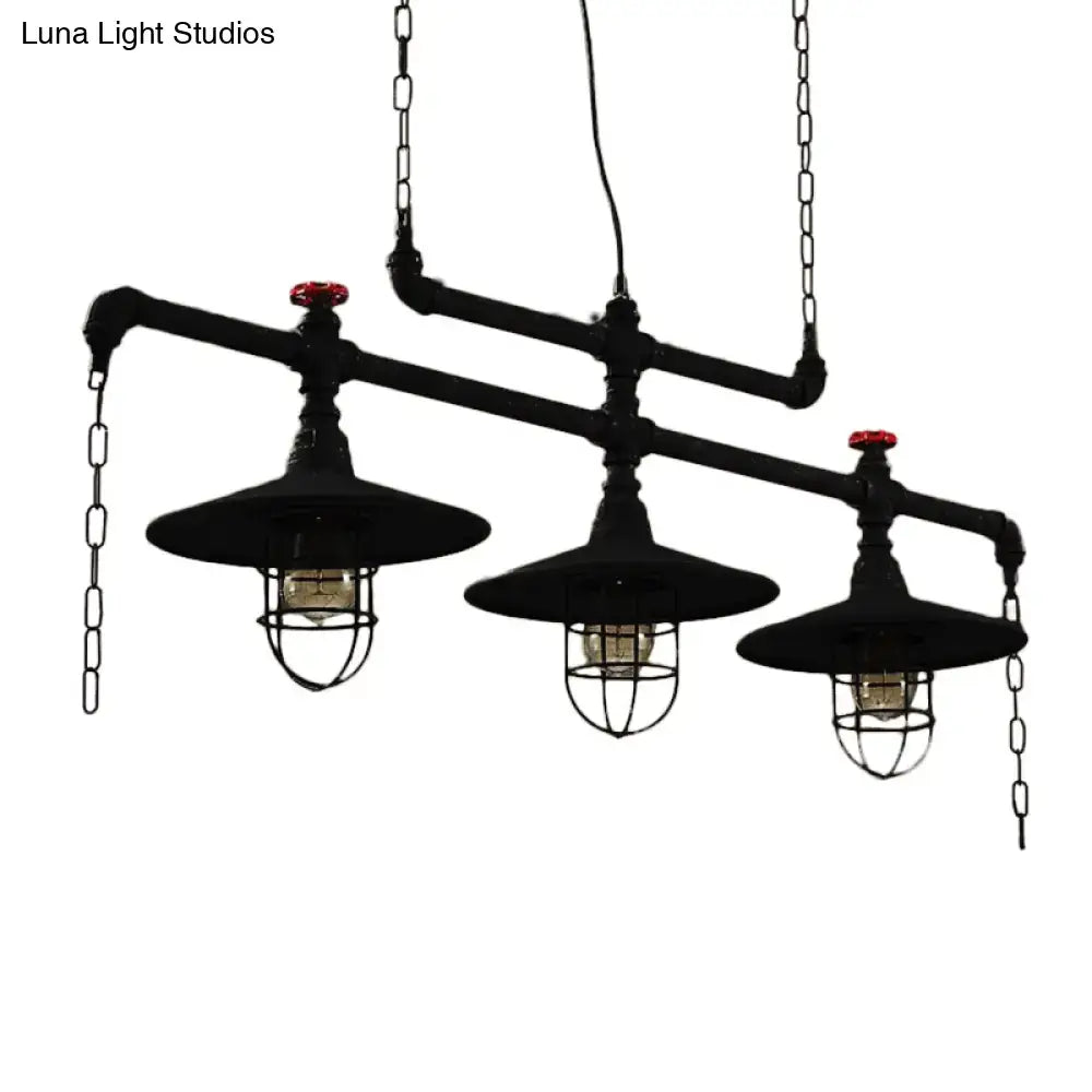 Industrial black pipe chandelier with three hanging lanterns featuring red valve caps and protective wire cages for dining room lighting