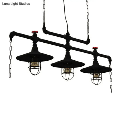 Industrial black pipe chandelier with red valve caps featuring two exposed bulbs and protective wire cages for dining room lighting