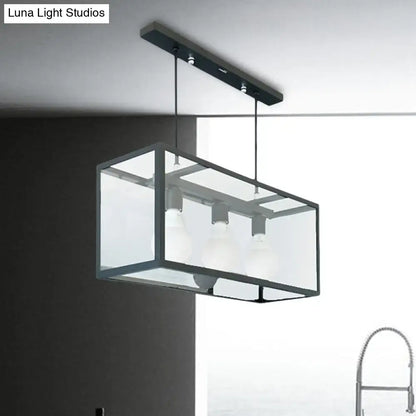 Modern rectangular pendant light with black metal frame and clear glass panels for industrial kitchen island use