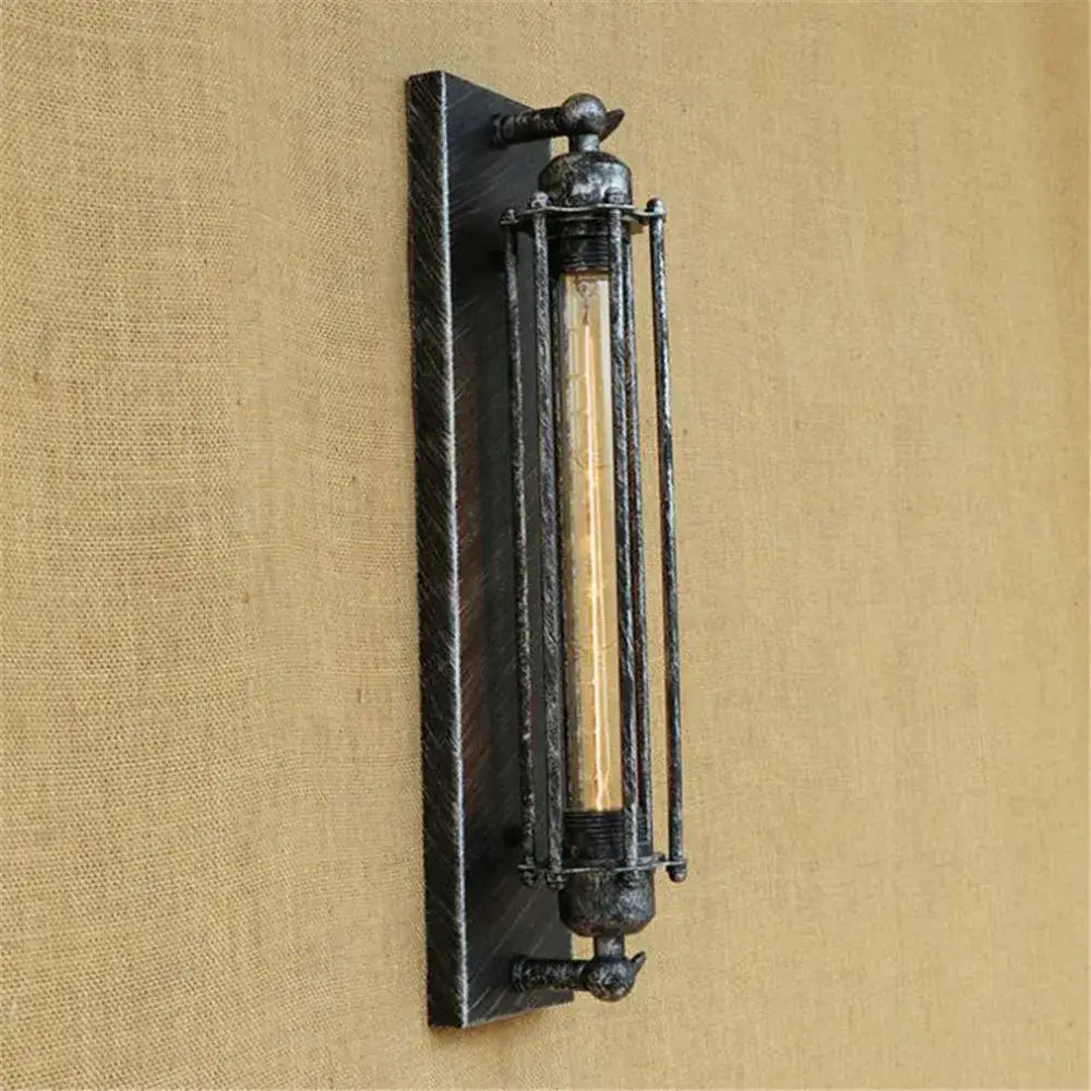 Industrial black rustic edison wall light with dark weathered metal frame and vertical bars encasing exposed filament bulb