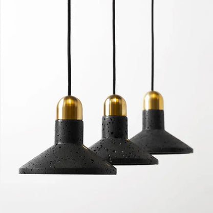 Industrial black travertine cement pendant light with black terrazzo shades and gold-toned brass caps for kitchen decor
