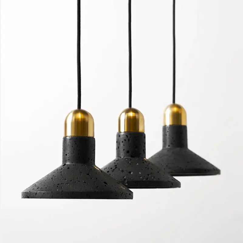 Industrial black travertine cement pendant light with black terrazzo shades and gold-toned brass caps for kitchen decor