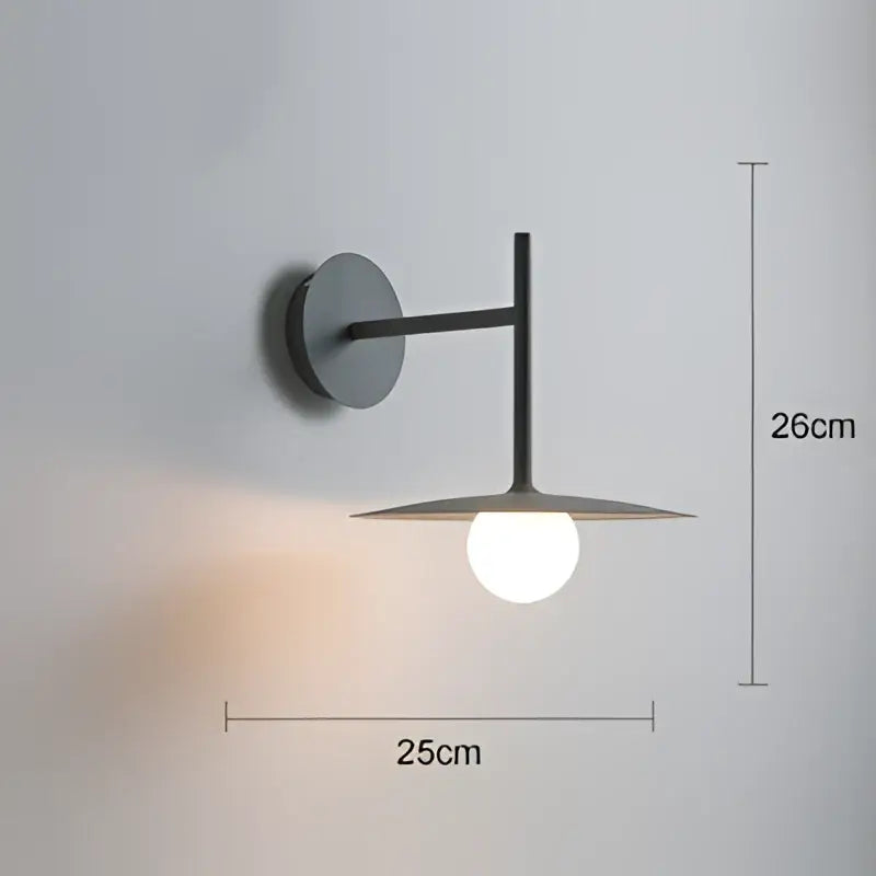 Modern black metal wall lamp with minimalist disc sconce design and warm glow for decorbites industrial style bedroom