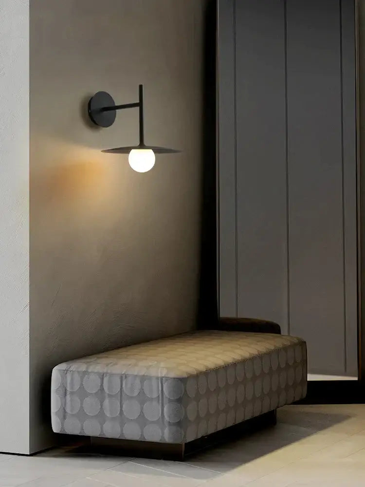 Modern black wall lamp with sleek minimalist disc design and warm white globe bulb for industrial style decorbites bedroom decor