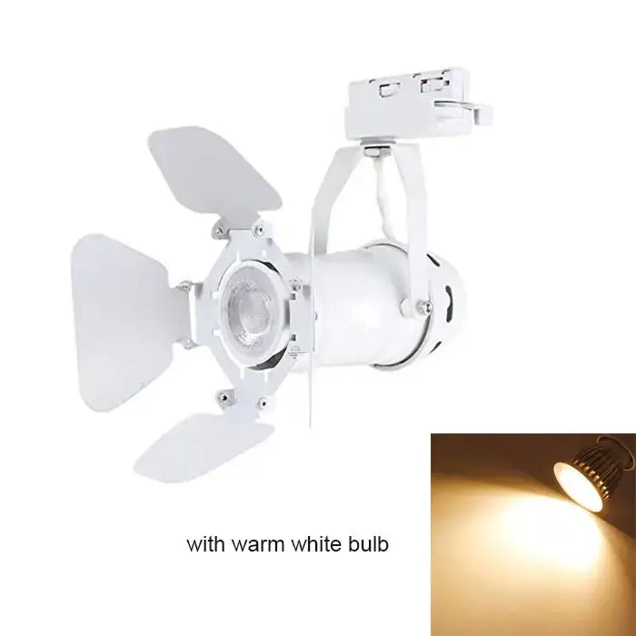 White adjustable industrial track spotlight with four leaf-shaped reflectors and warm white bulb for office use