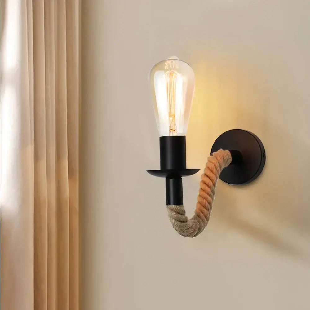 Industrial black metal wall lamp with coiled beige decorbites hemp rope arm and exposed filament bulb for bedroom decor