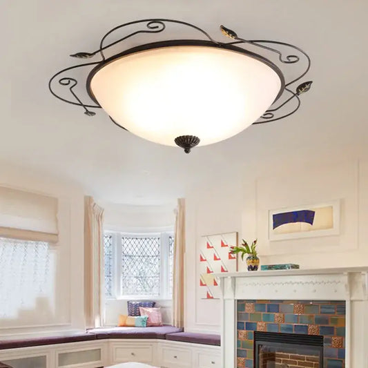 Industrial black wrought iron round ceiling light with ornate leaf design and frosted glass dome for bedroom use