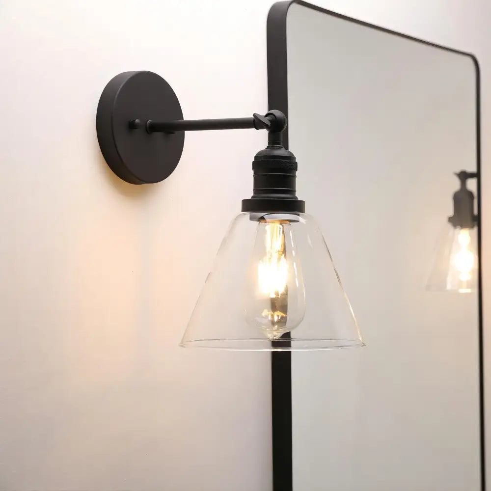 Industrial black wrought iron wall lamp with clear glass shade and exposed edison bulb for bedroom use
