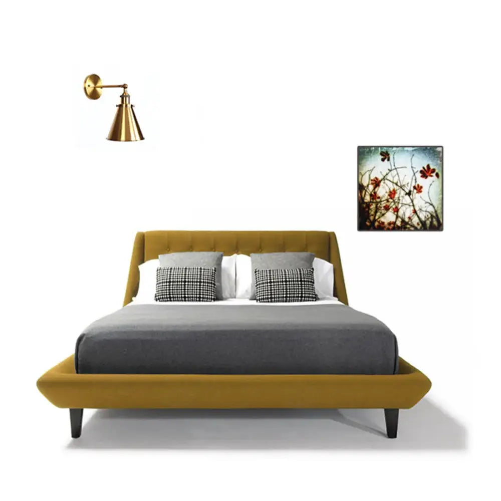Mustard-yellow upholstered bed with tufted headboard and footboard black legs gray bedding and wall sconce decorbites elegant gold