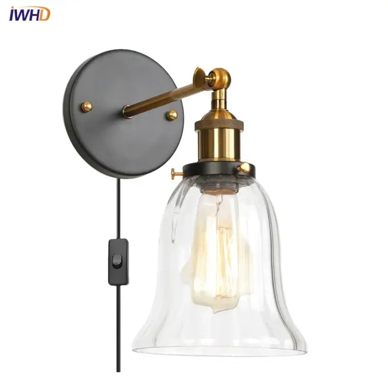 Brass-finished industrial clear glass wall sconce with a bell-shaped shade and exposed Edison bulb for bedroom decorbites industrial clear