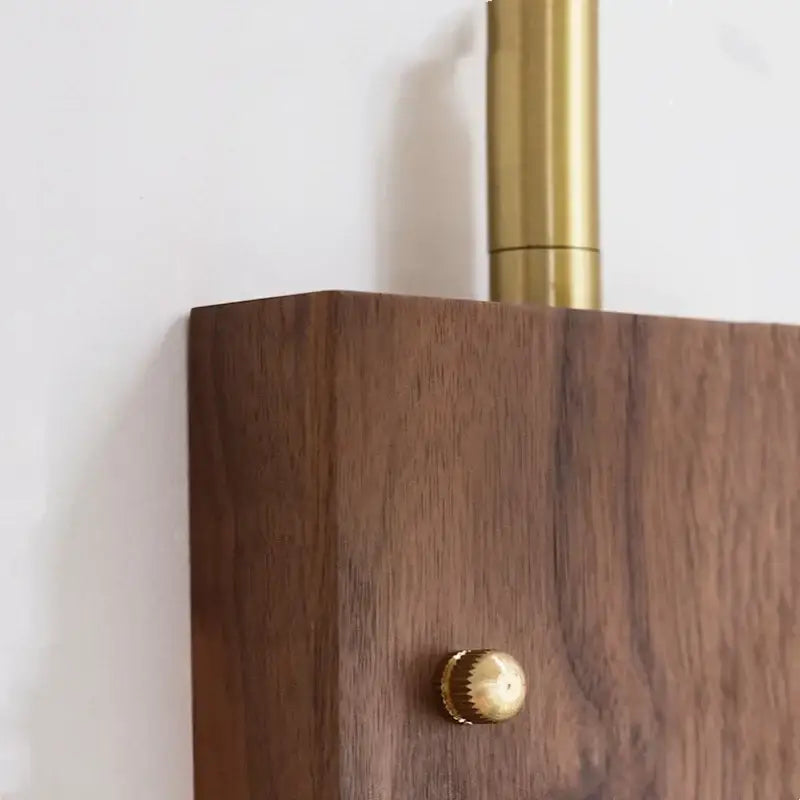 Dark wood cabinet with brass knob and vertical handle complementing industrial brass and walnut decorbites led wall light