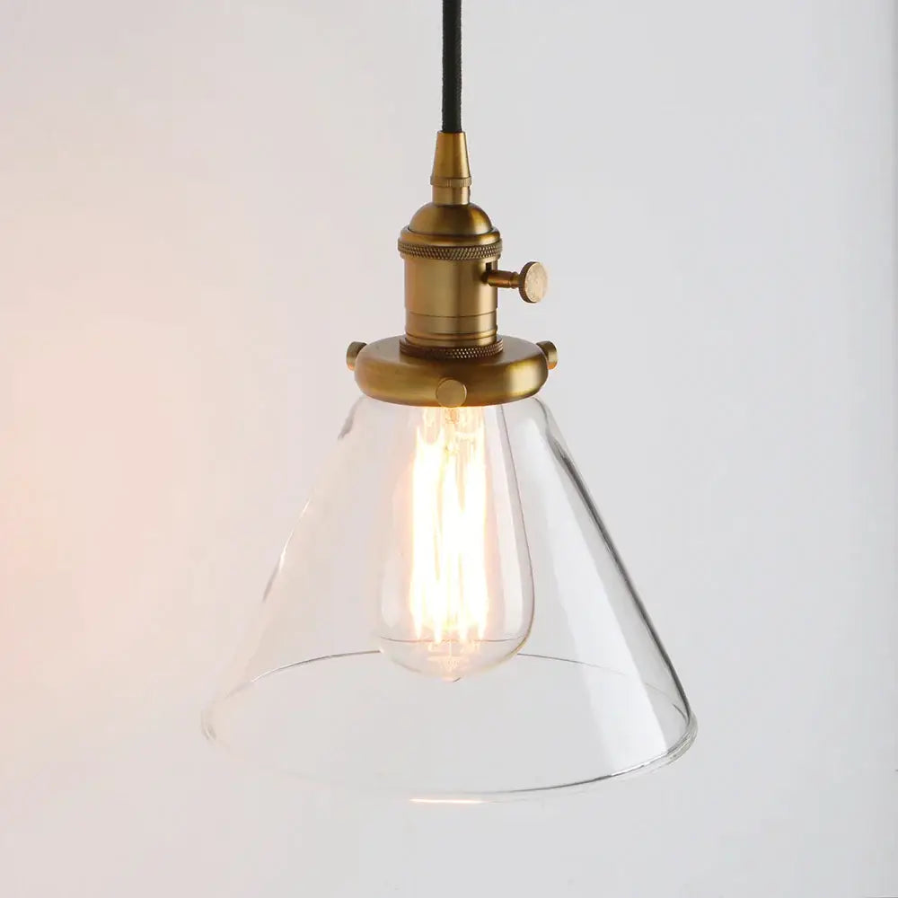 A clear funnel flared glass pendant light with brass finish and exposed filament bulb for kitchen decorbites funnel flared