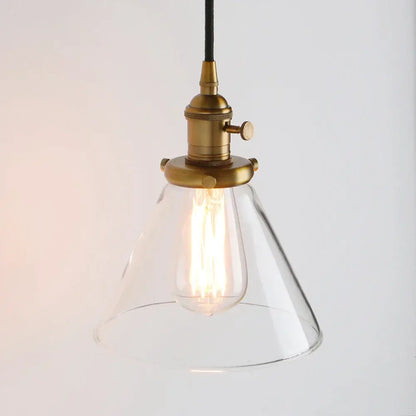 A clear funnel flared glass pendant light with brass finish and exposed filament bulb for kitchen decorbites funnel flared