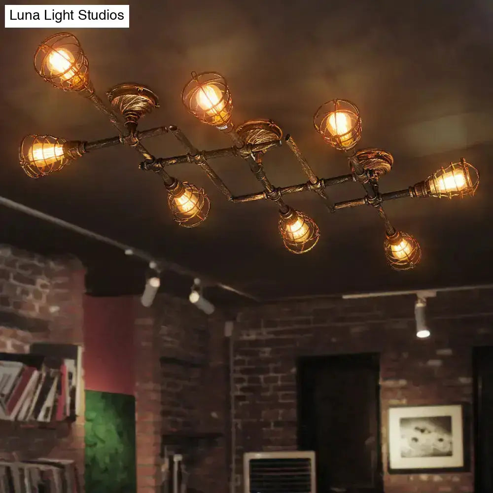 Industrial brass intersecting piping ceiling light with dark metal frame wire cages and warm amber bulbs for dining room