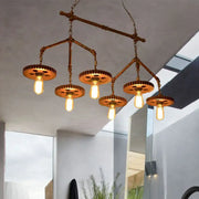 Industrial brass pipe island light fixture featuring rust finish metal with five exposed edison bulbs and gear shades