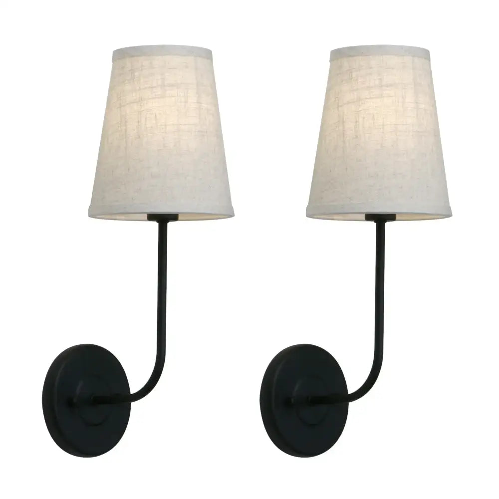 Pair of black wrought iron wall lamps with off-white linen shades in an industrial brass wall lamp set for bedroom reading