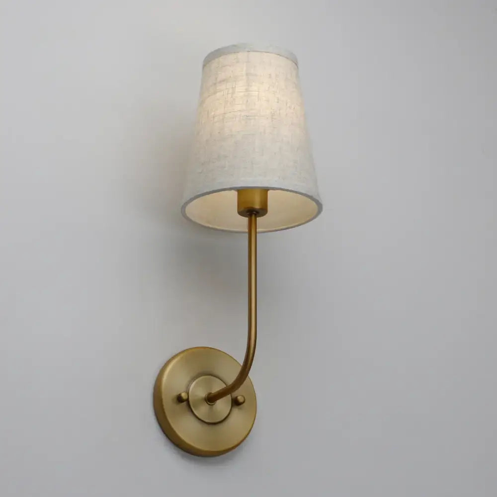 Industrial brass wall lamp set featuring a brass-finished wall lamp with a tapered off-white linen shade for bedroom reading light