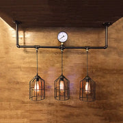 Decorbites™ bronze industrial linear hanging light with black pipe cage shades and a central pressure gauge for island lighting