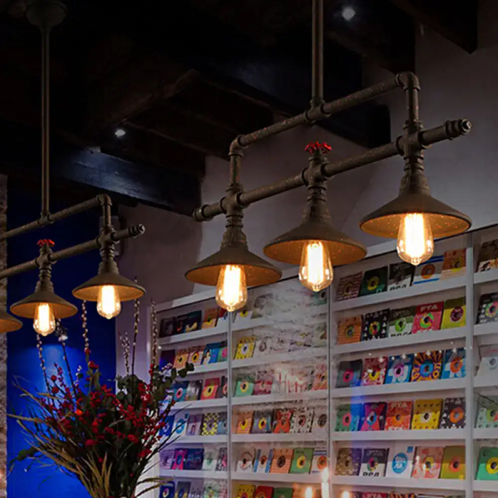 Industrial bronze pipe island light with five exposed edison bulbs and dark metal fixtures for dining room use
