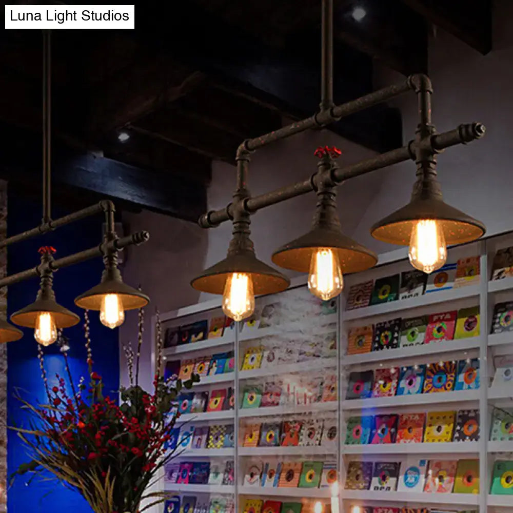 Industrial bronze pipe island light with five brass-colored pipe fixtures and exposed filament bulbs for dining room use